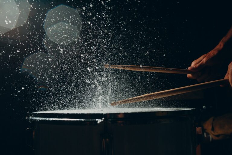 Drum sticks drumming beat rhythm on drum surface with splash water drops