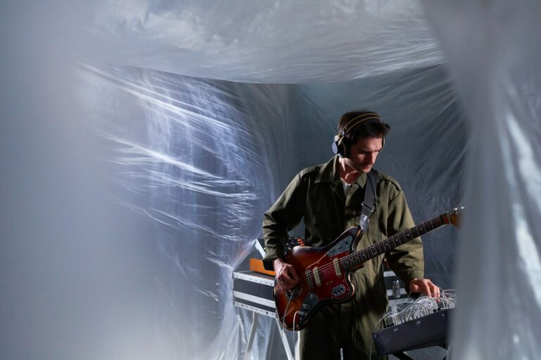 Guitarist Preparing Musical Equipment in Improvised Studio